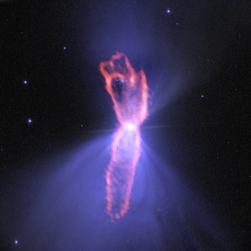 Forma alargada en tonos naranjas sobre la silueta azulada de doble lóbulo de la nebulosa Boomerang